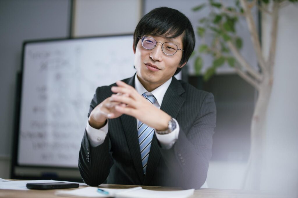 オフィスで資料を見ながら説明する男性会社員